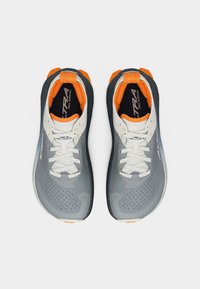 Ζευγάρι γκρι και πορτοκαλί παπούτσια για τρέξιμο σε μονοπάτια Altra με λευκά κορδόνια, προβολή από πάνω σε λευκό φόντο.