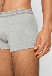 Graue Baumwoll-Boxershorts mit einer figurbetonten Passform, ausgestattet mit einem strukturierten Bund mit "Calvin Klein"-Markenlogo und glatten Beinöffnungen.