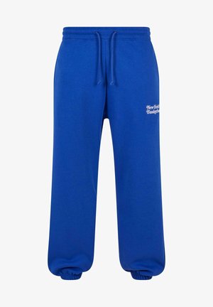 Sinise puuvillased spordipüksid, millel on nööriga vöökoht ja elastsed pahkluupüksid. Esiküljel on valge teksti disain "New York Basketball."