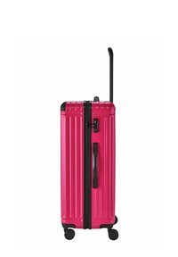Valigia rigida di colore rosa brillante, con scanalature verticali, cerniera nera e manico retrattile. Include quattro ruote per la mobilità.