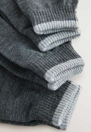 Graue Socken gestapelt, mit einem gerippten Textur und einem hellgrauen Bündchen. Das Material scheint weich und flauschig zu sein und zeigt eine einheitliche Farbe.
