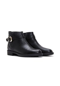 Botas de cuero negras hasta el tobillo con un panel lateral acolchado, correa con hebilla, suela plana y diseño de punta redonda.