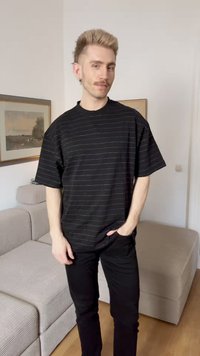 Μαύρο κοντομάνικο T-shirt με οριζόντιες ρίγες, στρογγυλή λαιμόκοψη, άνετη εφαρμογή, σε συνδυασμό με μαύρο παντελόνι. Μαλακό ύφασμα με απαλές υφασματικές λεπτομέρειες.