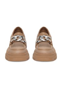 Bežové síťované mokasíny s tlustou gumovou podrážkou a velkým stříbrným řetízkovým detailem vpředu, zobrazené z čelního pohledu.