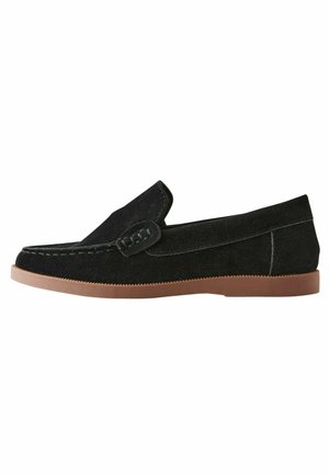 Mocassins en cuir suédé noir avec une texture douce, dotés d'un dessus cousu et d'une semelle en caoutchouc brun flexible. Conçus avec un profil élancé et un petit empeigne.