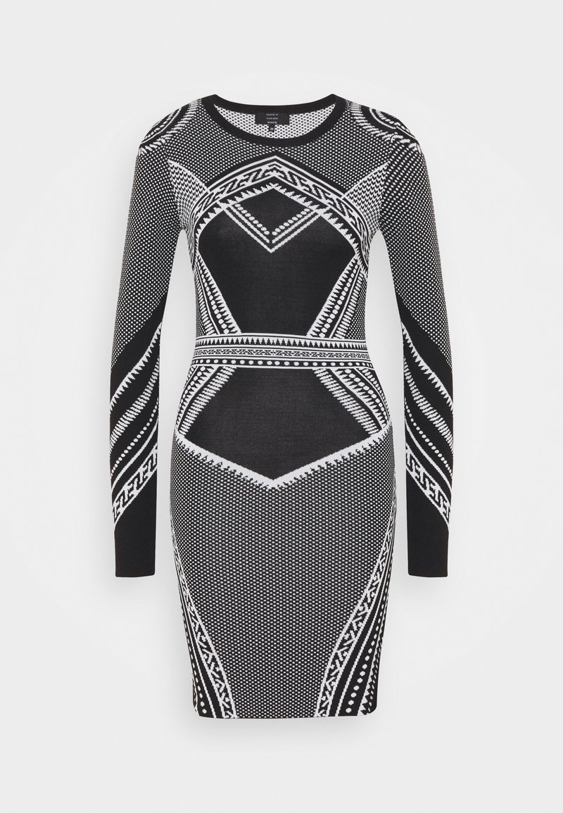 Robe moulante à manches longues en noir et blanc avec des motifs géométriques et tribaux, silhouette ajustée et encolure ronde.