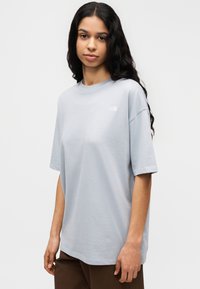 Ανοιχτό μπλε βαμβακερό μπλουζάκι με στρογγυλή λαιμόκοψη και κοντά μανίκια. Διαθέτει μικρό λευκό λογότυπο στο στήθος. Σχεδίαση με χαλαρή εφαρμογή.