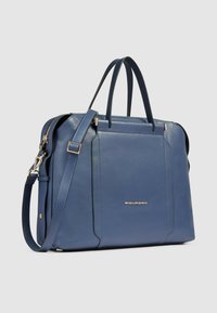 Bolso estructurado de cuero azul con doble asa superior y correa de hombro desmontable. Presenta herrajes en tono dorado y un diseño elegante.