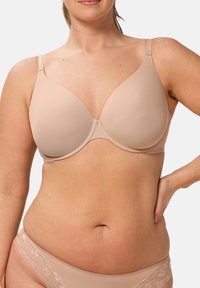 Nude BH mit glatten, gepolsterten Körbchen und verstellbaren Trägern. Nahtloses Design; passt zu passenden Panties mit Spitzenakzenten. Einfach und funktional.