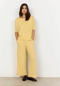 Geel, luchtige top met korte mouwen en bijpassende wijde broek. Gemaakt van zachte, gestructureerde stof, met zakken en een casual ontwerp.