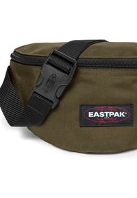 Kaki Eastpak midjeväska med rund form, dragkedjestängning, svart justerbar rem och en framträdande röd och svart logotyp på sidan.