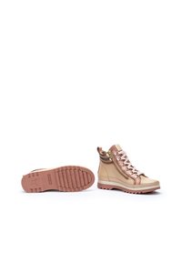 Botas altas beige con acentos rosas, cierre de cordones y cremallera lateral. Suela de goma texturizada con patrones de agarre. Acabado de cuero suave.