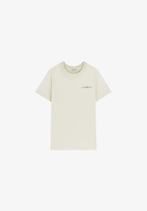 Beige krátký rukáv tričko s kulatým výstřihem a malým černým logem "THE SCALPERS CO." na levé hrudi.