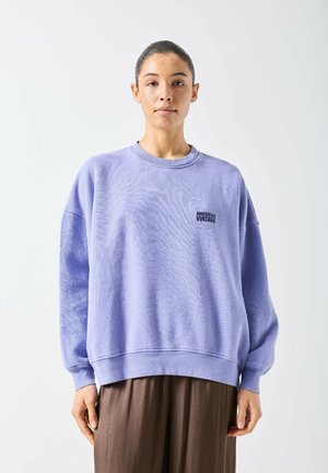 Felpa viola in tessuto morbido, con scollo tondo, spalle scese e logo nero "American Vintage" sul lato sinistro.