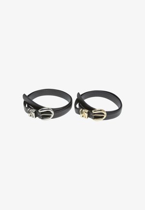 Deux bracelets en cuir noir avec des boucles lisses et arrondies ; l'un présente une boucle en argent, l'autre une boucle en or ; les deux ont une texture douce.