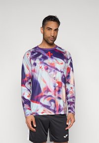 Atletska majica z dolgimi rokavi z večbarvnim, abstraktnim vzorcem v vijolični, rožnati in rdeči barvi ter kontrastnim rdečim logotipom na prsih.