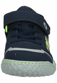 Sneaker in tessuto blu navy con strap in Velcro, dettagli argento e verdi, suola testurizzata e bordo intrecciato. Design con lacci realizzato con materiali resistenti.