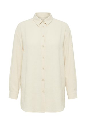 Langärmeliges, cremefarbenes Hemd mit Knöpfen und spitzem Kragen sowie strukturierter Stoffoberfläche, dargestellt auf weißem Hintergrund.