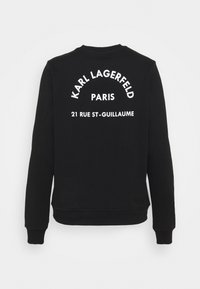 Černá mikina s bílým nápisem na zádech: "KARL LAGERFELD", "PARIS" a "21 RUE ST-GUILLAUME", s kulatým výstřihem a žebrovanými manžetami.