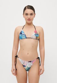 Ensemble de bikini avec un motif floral multicolore, comprenant un haut triangulaire et un bas à nouer sur les côtés, fabriqué en tissu lisse avec des accents noirs.