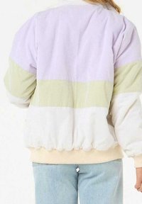 Kleurige jas met lavendel-, groene en witte panelen. Gemaakt van zachte stof met geribbelde textuur en elastische manchetten en zoom.