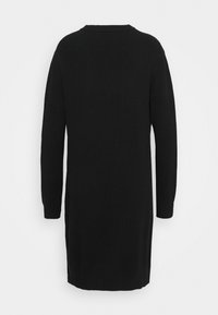 Robe noire en tricot côtelé à manches longues avec encolure ronde, vue de dos, tombant au-dessus du genou.