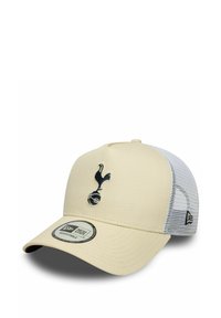 Cremfarbener Baseballschläger mit einem dunkelblauen, gestickten Logo eines Vogels und einem Fußball. Er hat einen weißen Mesh-Rücken und einen gebogenen Schirm.