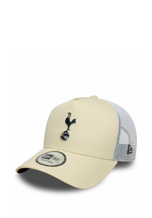 Cappellino da baseball color crema con un logo ricamato in blu scuro raffigurante un uccello e un pallone da calcio, caratterizzato da un retro in rete bianca e una visiera curva.