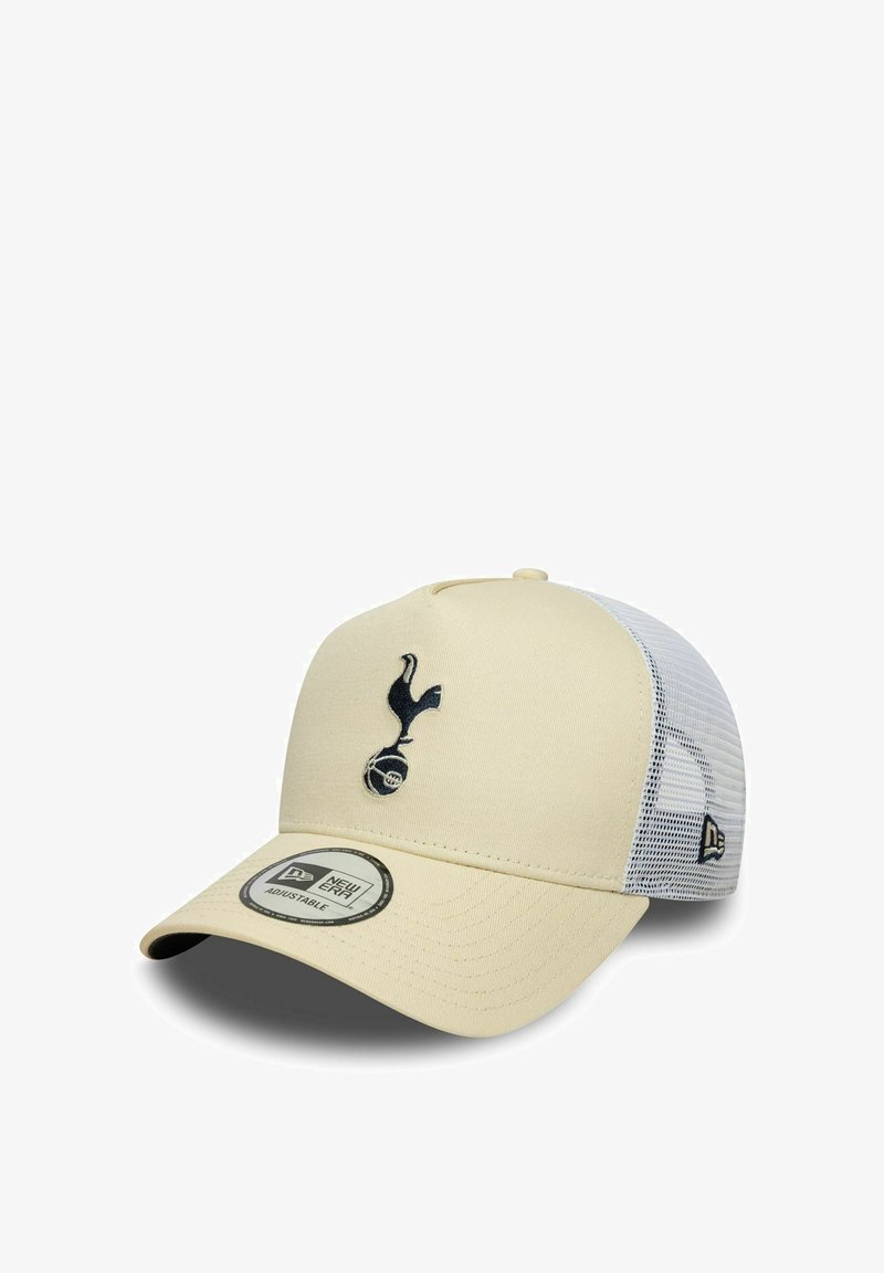 Cremfarbener Baseballschläger mit einem dunkelblauen, gestickten Logo eines Vogels und einem Fußball. Er hat einen weißen Mesh-Rücken und einen gebogenen Schirm.