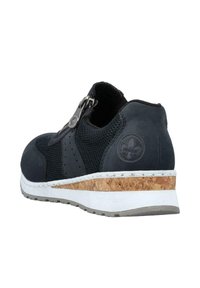 Svart sneaker med meshtyg och mockadetaljer, sidodragkedjestängning, korkmittsula och vit yttersula. Har en logodetalj på sidan.