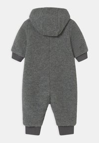 Tuta intera grigia in pile con cappuccio, maniche corte e polsini a costine. Tessuto morbido, design strutturato e senza decorazioni aggiuntive.