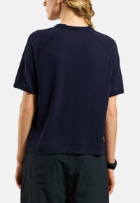 Top navy blu, a maniche corte, con texture e vestibilità rilassata, caratterizzato da scollatura rotonda e maniche raglan. Design semplice, senza pattern.