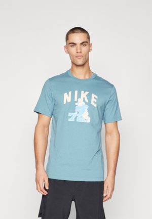 Blue cotton t-shirt featuring "NIKE" and a graphic of a character with the number "72" underneath. Short sleeves and a round neckline.