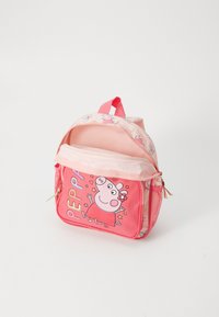 Roza otroška nahrbtnik z likom Peppe Pig in barvnimi črkami, ki ima mrežaste stranske žepe in ročaj na vrhu.