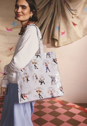 Natisnjena torba za večkratno uporabo iz sijočega materiala, na svetlo sivi podlagi s plesalci v različnih barvah. Dolgi ročaji, kvadratna oblika.