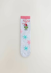 Šedá ponožka s ružovým lemom, s postavičkou v zelenom, ktorá má na hlave santovskú čiapku, a s vzormi snehových vločiek v modrej a ružovej farbe.