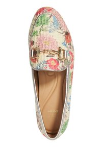 Mocassin imprimé floral avec un dessus en tissu texturé, accent en métal doré et bord argenté autour de l'ouverture. Semelle intérieure beige visible à l'intérieur.