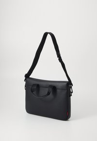 Black leather laptop bag with textured surface, dual handles, adjustable strap, and a subtle red accent on the side.