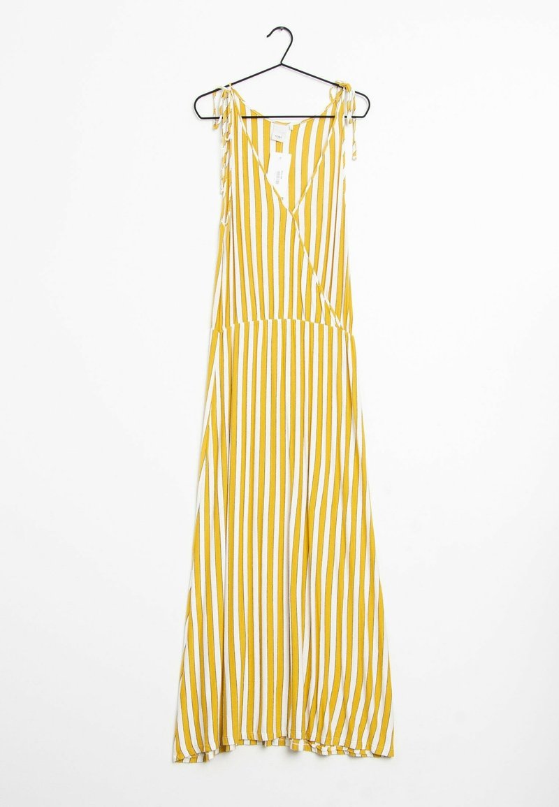 Żółto-biała, pionowo paskowana, bezrękawnikowa sukienka maxi z wiązanymi ramiączkami wisi na czarnym wieszaku.