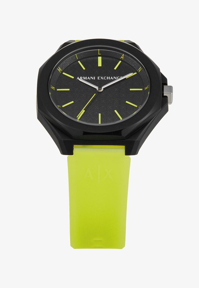 Reloj octagonal negro con esfera texturizada, acentos verdes y una brillante correa de goma amarilla. Presenta manecillas plateadas y un logo de A|X.