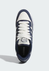 Las zapatillas Adidas en azul y blanco cuentan con una parte superior de cuero y gamuza, punta perforada, cuello acolchado, cordones blancos planos y un logotipo de baloncesto en la lengua.