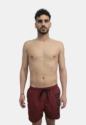 Costumi da bagno rossi da uomo con logo nero "BOSS", realizzati in tessuto leggero, con vita elasticizzata e dettagli con cordino.