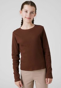 Top marrone a maniche lunghe realizzato in tessuto a coste con collo rotondo. La maglietta ha una silhouette aderente e una texture liscia.