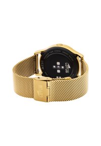 Montre intelligente dorée avec un bracelet en métal maillé, un cadran circulaire noir et des capteurs de lumière. Présente un logo sur le bracelet et une fermeture par clip.