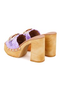 Lila geflochtene Plateauschuhe mit einem Holzblockabsatz, versehen mit metallischen Akzenten und Nieten entlang der Kante. Glattes Innenfutter.