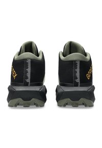Scarpe da trail nere e verde oliva con una tomaia in tessuto testurizzato, tallone rinforzato e suola robusta. Presentano il marchio GORE-TEX.