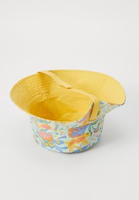 Ένας πολύχρωμος υфατικός κουβάς με λουλουδάτο σχέδιο σε παστέλ αποχρώσεις και κίτρινο εσωτερικό, που διαθέτει αναδιπλούμενη άκρη και ανθεκτική λαβή.