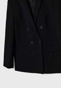 Black double-breasted blazer made of smooth fabric, featuring two front pockets, four buttons, and a satin-lined interior.