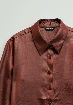 Camisa de manga larga de cuero sintético marrón con cuello puntiagudo, cierre con botones y etiqueta visible "Salsa Jeans" en el interior del cuello.