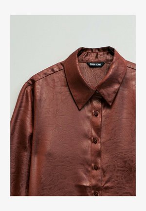 Camisa de manga larga de cuero sintético marrón con cuello puntiagudo, cierre con botones y etiqueta visible "Salsa Jeans" en el interior del cuello.